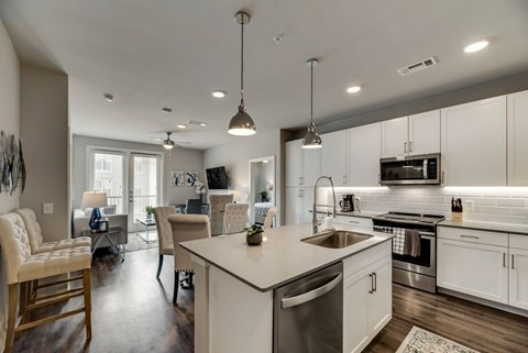 an open kitchen and living room with a large counter top