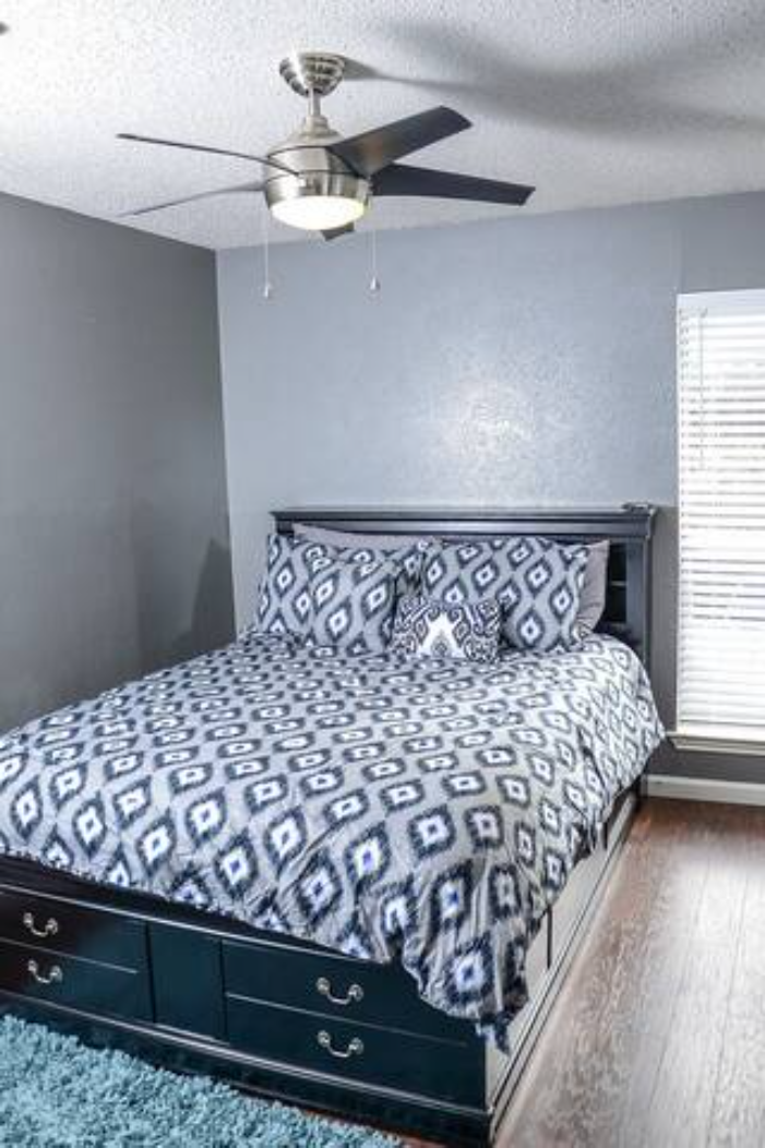 a bedroom with a bed and a ceiling fan