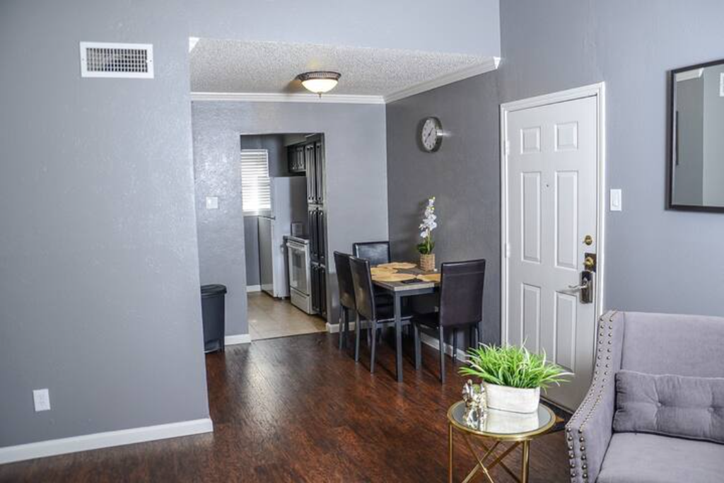 a living room and dining room with a table and chairs