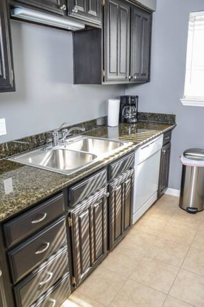 a kitchen with a stainless steel sink and cabinets