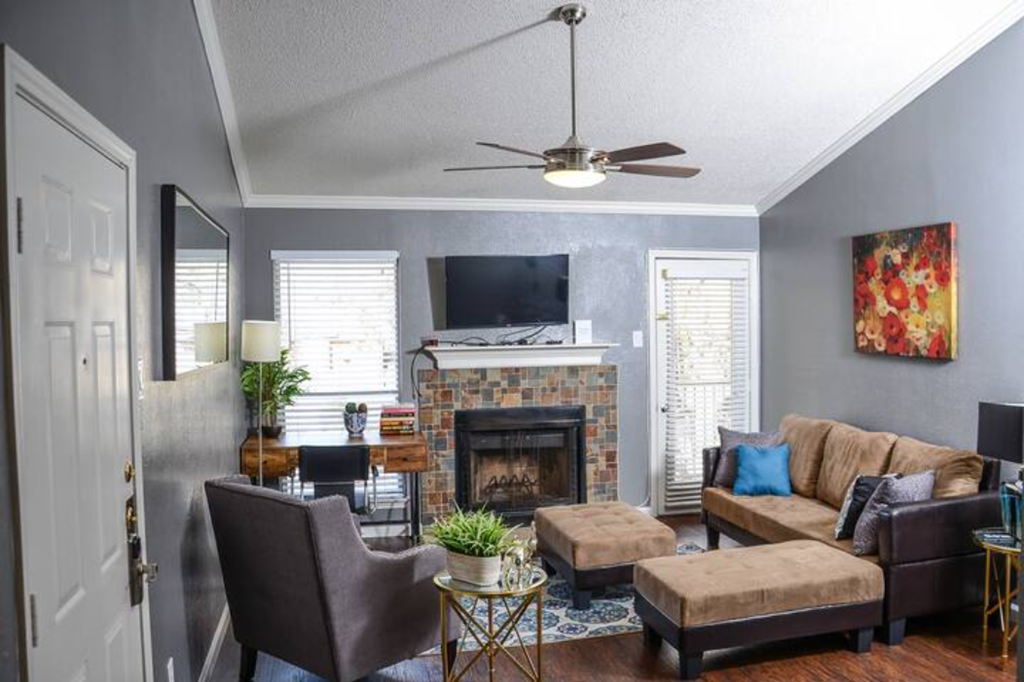 a living room with a fireplace and a ceiling fan