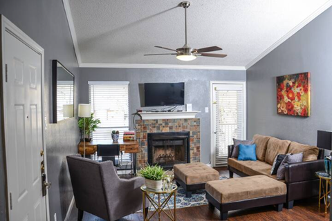 a living room with a fireplace and a ceiling fan