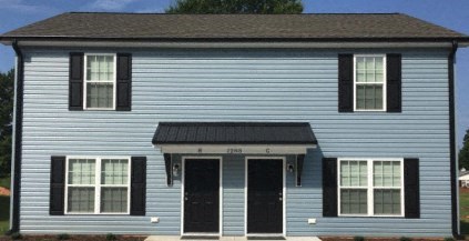 the front of a blue house with black doors and a black roof