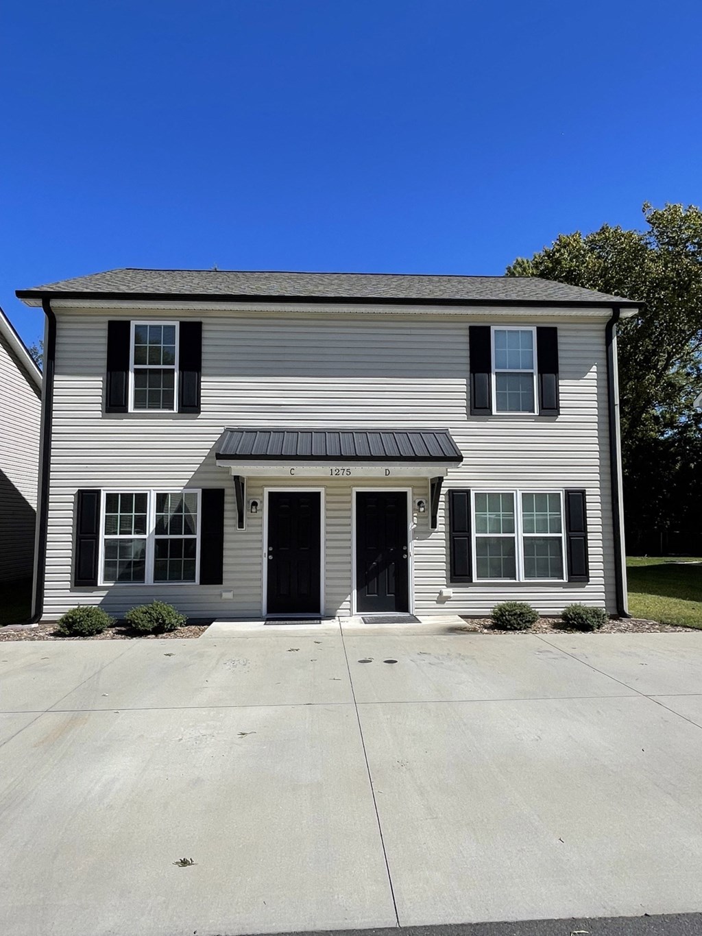 a white house with black shutters and a driveway