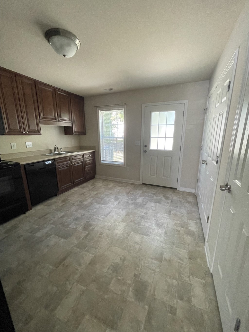 an empty kitchen with wooden cabinets and a door