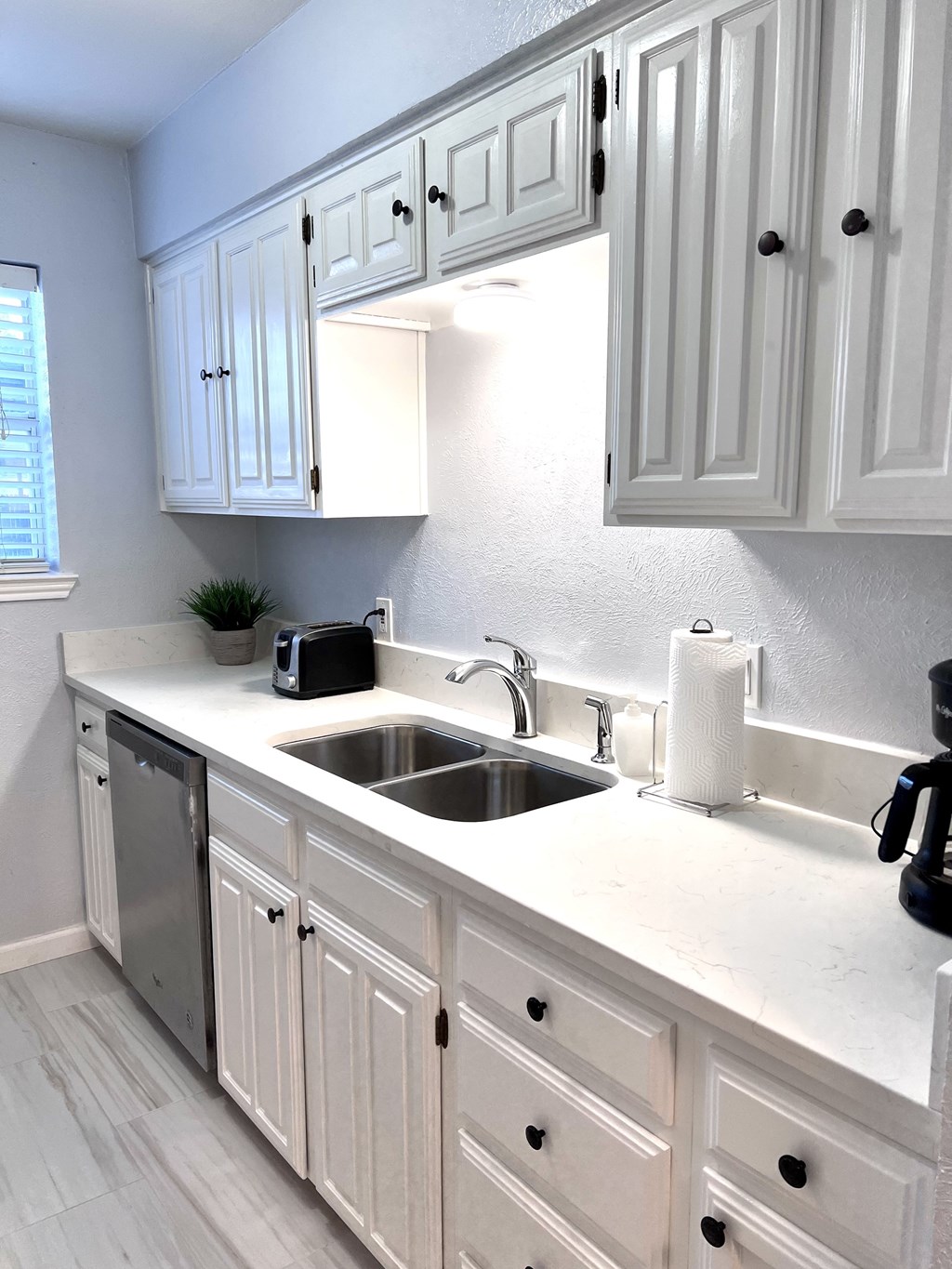 a kitchen with white cabinets and a sink