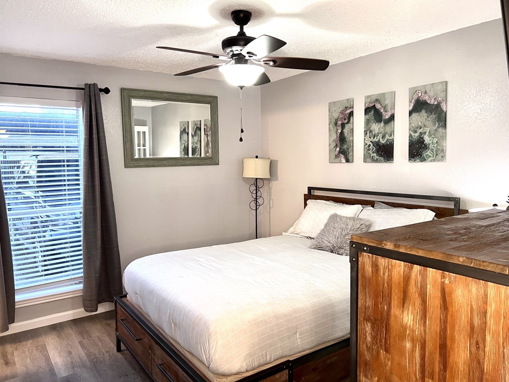 a bedroom with a bed and a ceiling fan