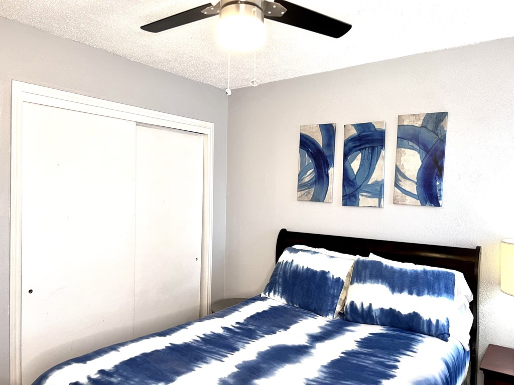 a bedroom with a bed and a ceiling fan
