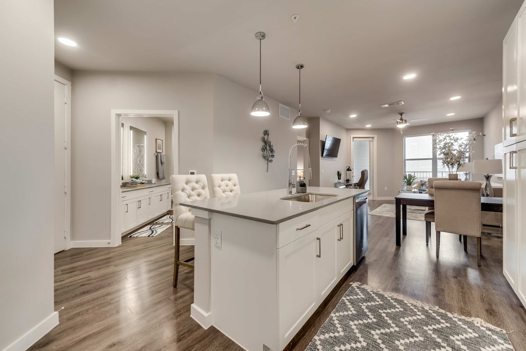 a white kitchen with a dining room and a living room