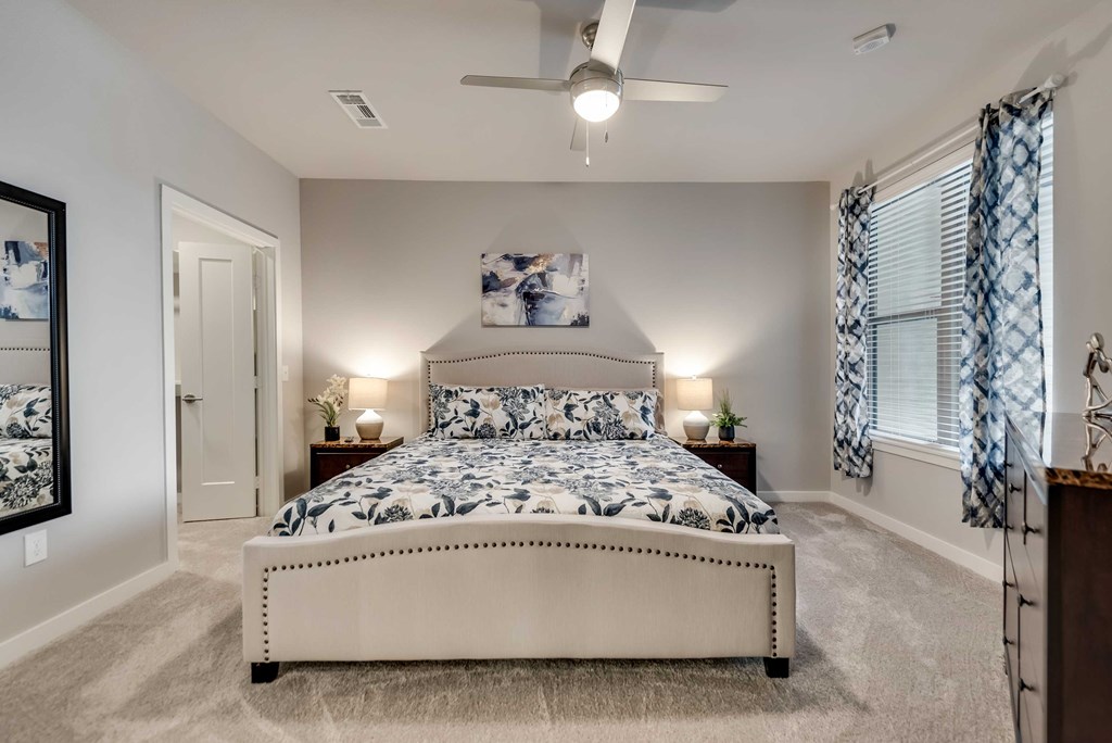 a bedroom with a bed and a ceiling fan