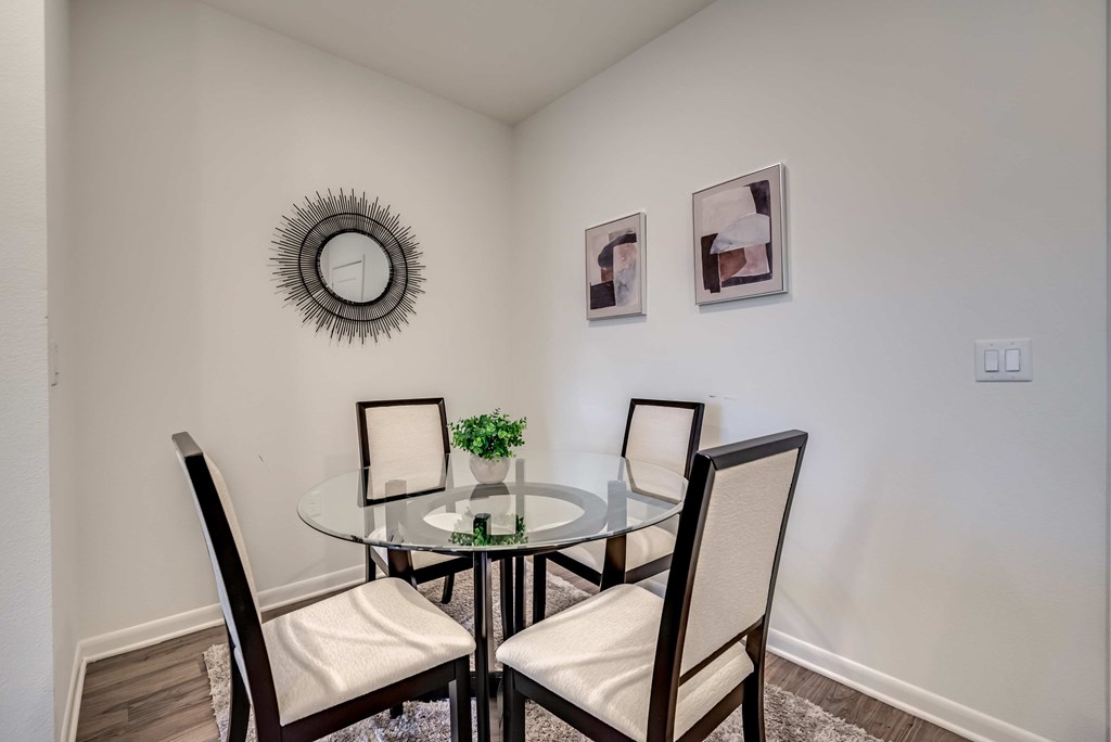a dining room with a glass table and four chairs