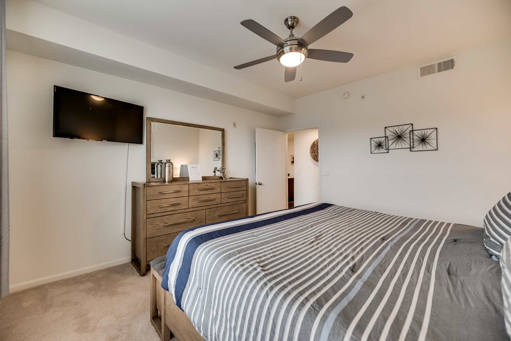 a bedroom with a bed and a ceiling fan