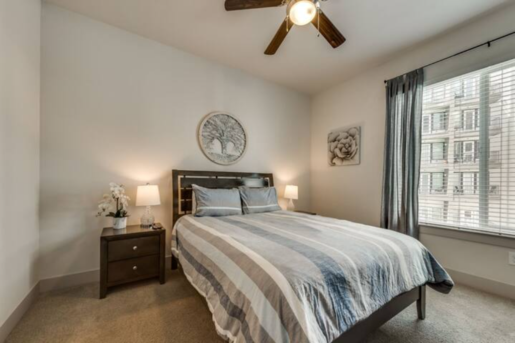 a bedroom with a bed and a ceiling fan