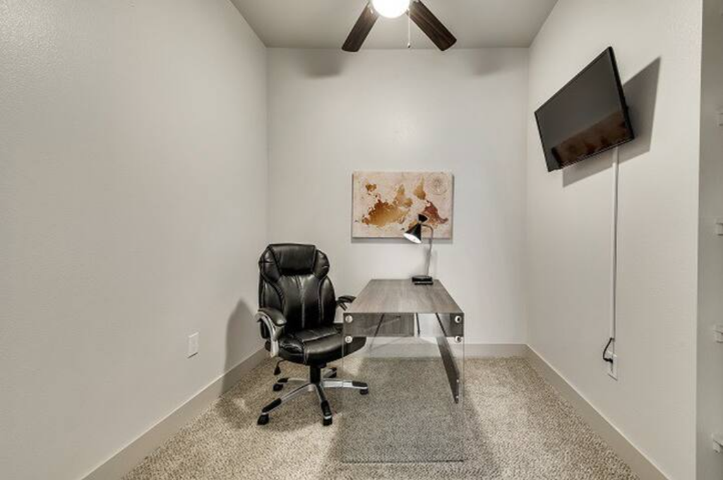 a white office with a desk and a chair
