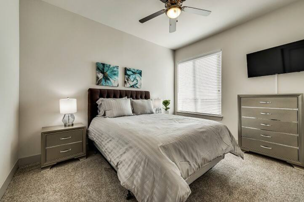 a bedroom with a bed and a ceiling fan