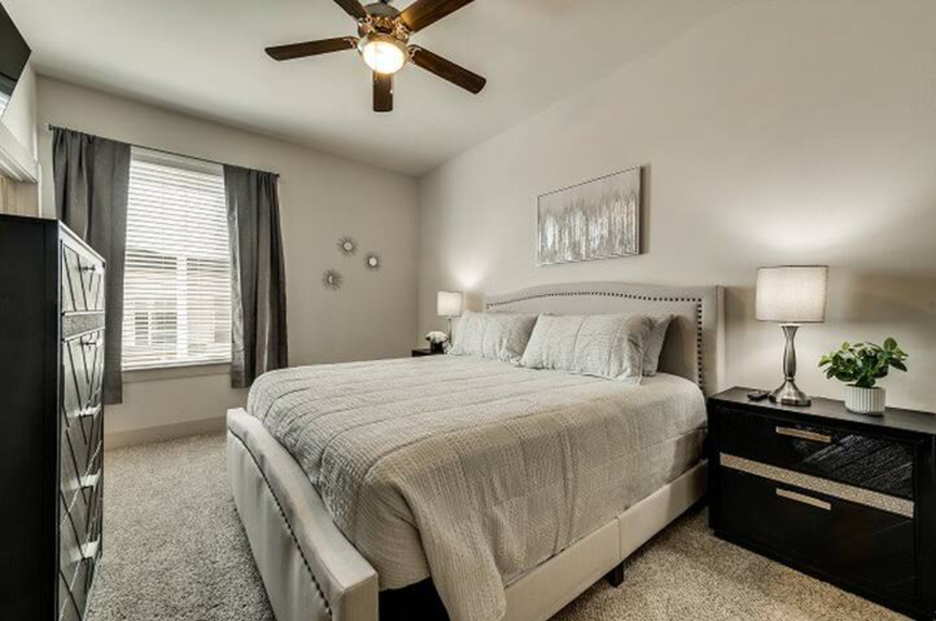 a bedroom with a bed and a ceiling fan