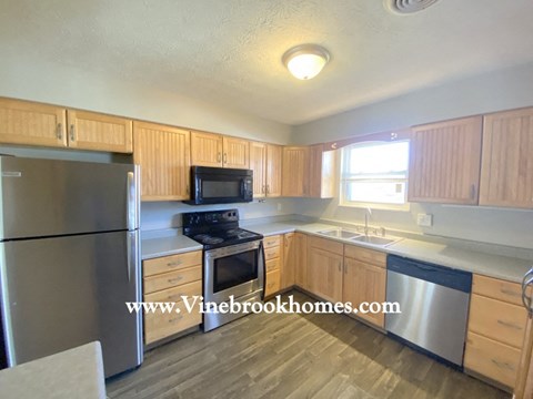 a kitchen with wooden cabinets and stainless steel appliances