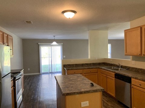 A kitchen with wooden cabinets and a granite countertop.