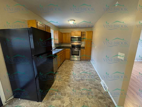 a kitchen with black appliances and wood cabinets