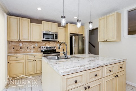 a kitchen with ivory cabinets and marble counter tops