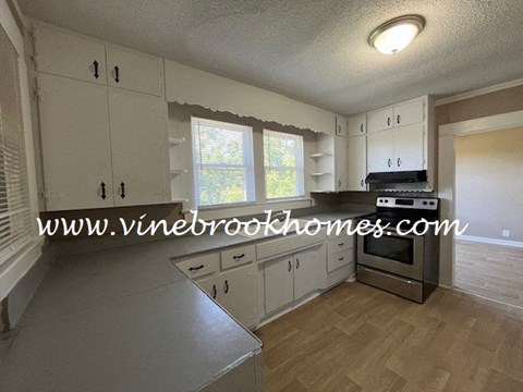 a kitchen with white cabinets and a stove and