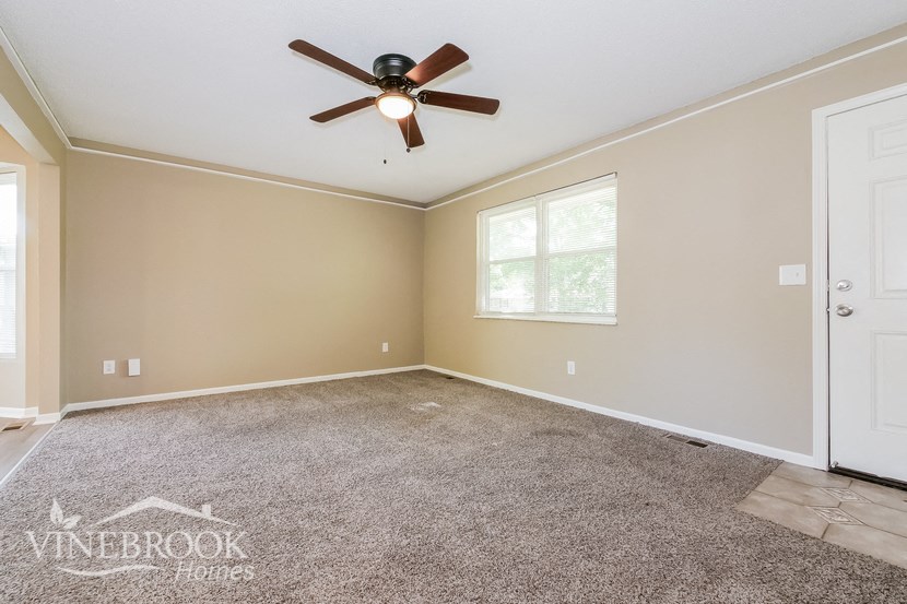 the master bedroom has a carpeted floor and a ceiling fan