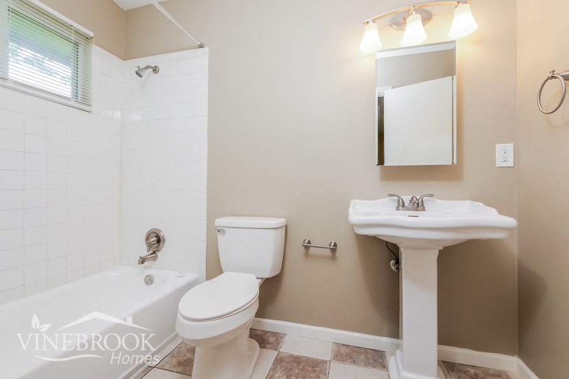 a bathroom with a toilet and a sink and a bath tub