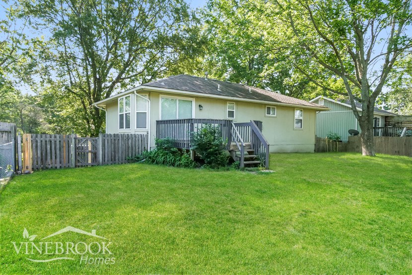 a small house with a yard and a fence
