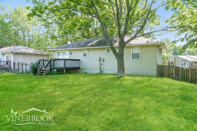 a white house with a yard and a tree