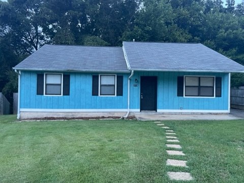 A blue house with a black door and windows.