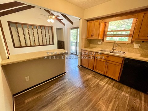 A kitchen with wooden cabinets and a ceiling fan.