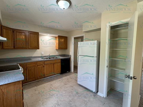 a kitchen with a refrigerator and a sink
