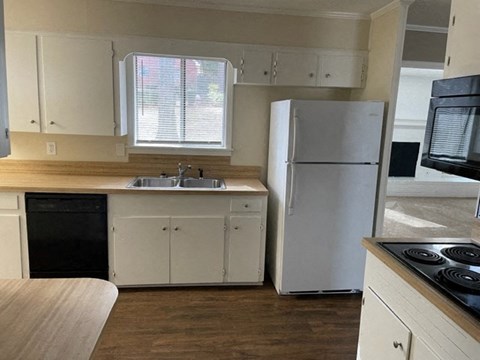 A kitchen with white cabinets and a white refrigerator.