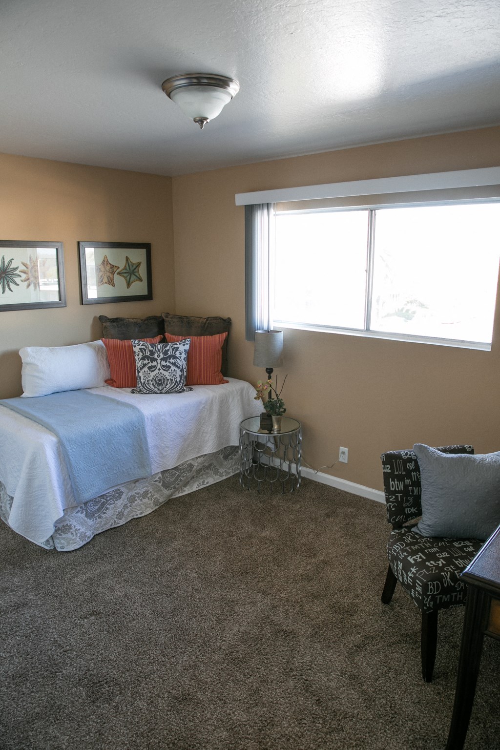 a bedroom with a bed and a chair and a window