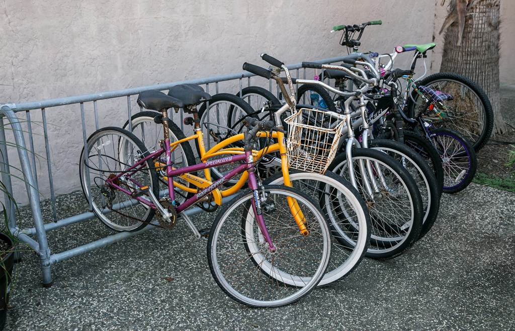 a group of bikes parked next to a fence