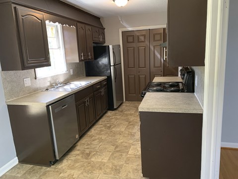 a kitchen with stainless steel appliances and brown cabinets
