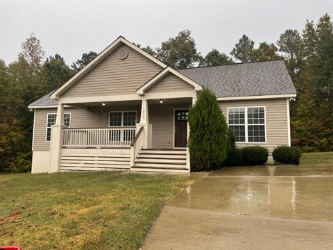 A house with a grey roof and a porch.
