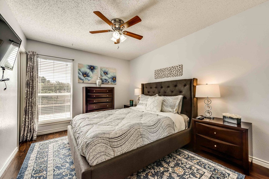 a bedroom with a bed and a ceiling fan
