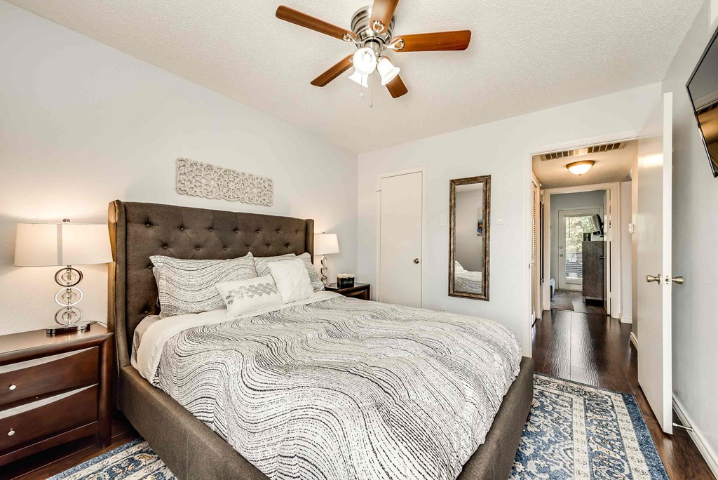 a bedroom with a bed and a ceiling fan