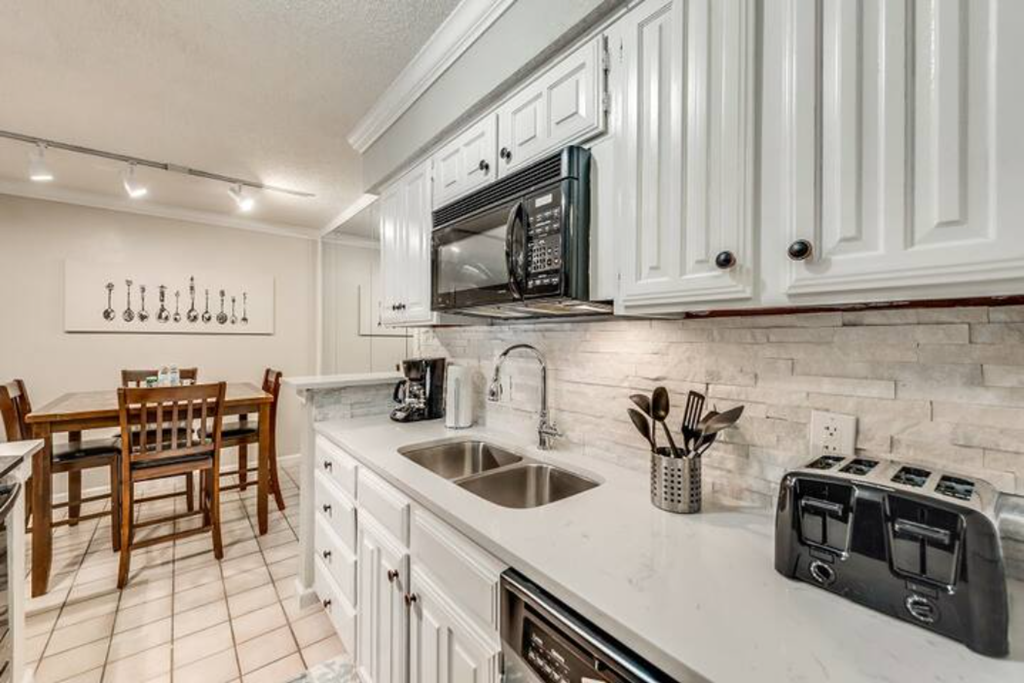a kitchen with white cabinets and a sink and a microwave