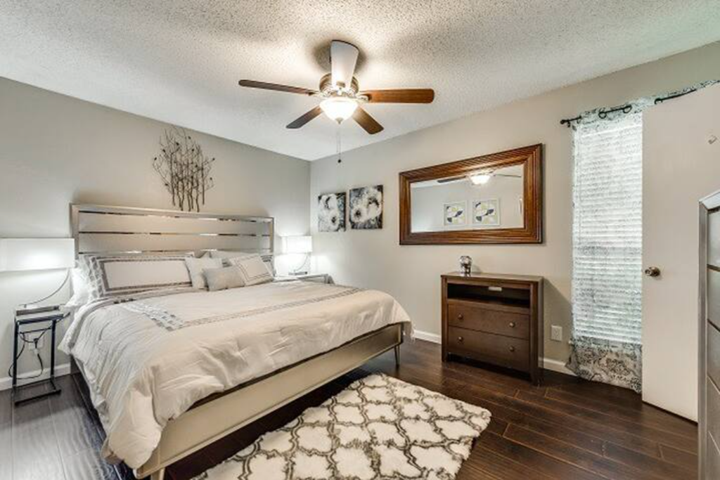 a bedroom with a bed and a ceiling fan