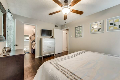 a bedroom with a large bed and a ceiling fan