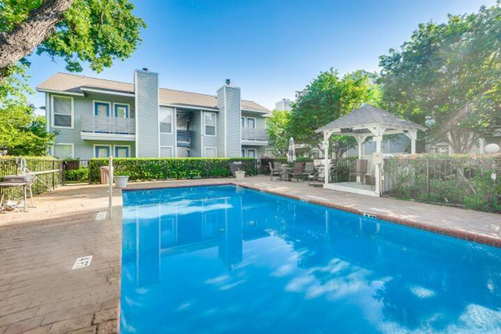 a pool with a gazebo and a house in the background