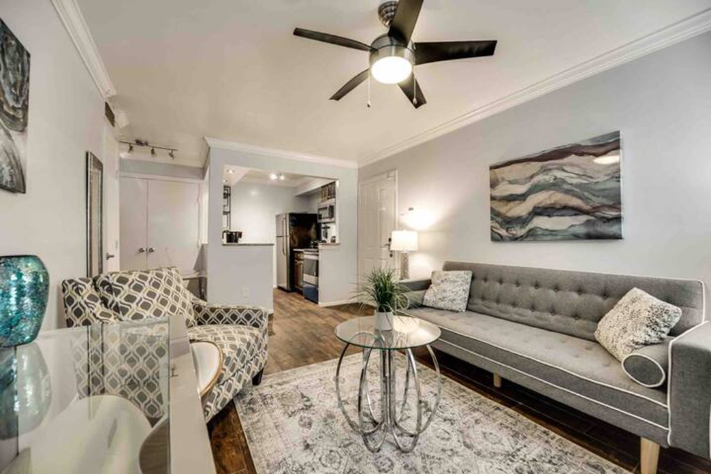 a living room with furniture and a ceiling fan