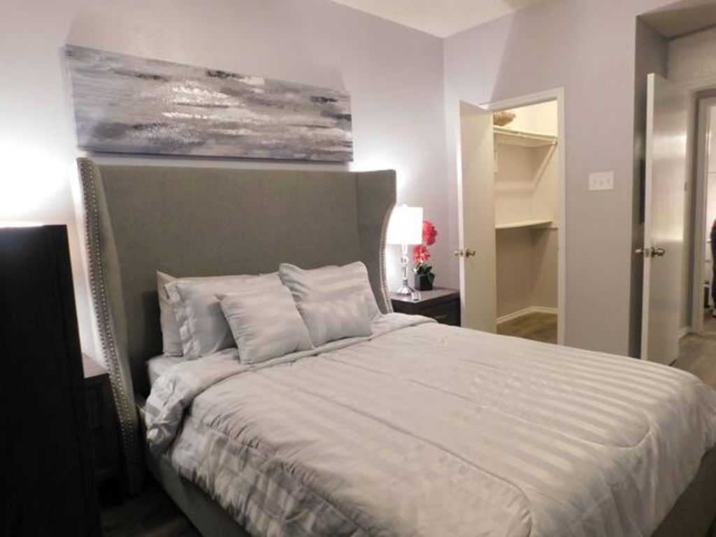 a bedroom with a large bed and a painting on the wall