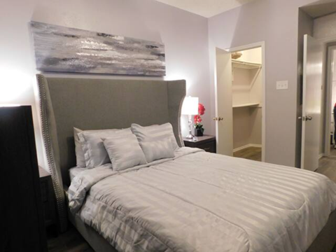 a bedroom with a large bed and a painting on the wall