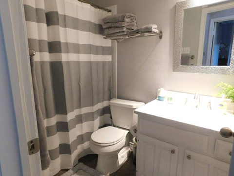 a bathroom with a striped shower curtain and a toilet