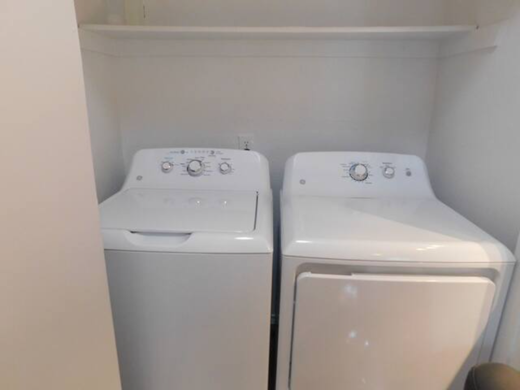 two white washers and dryers in a white room