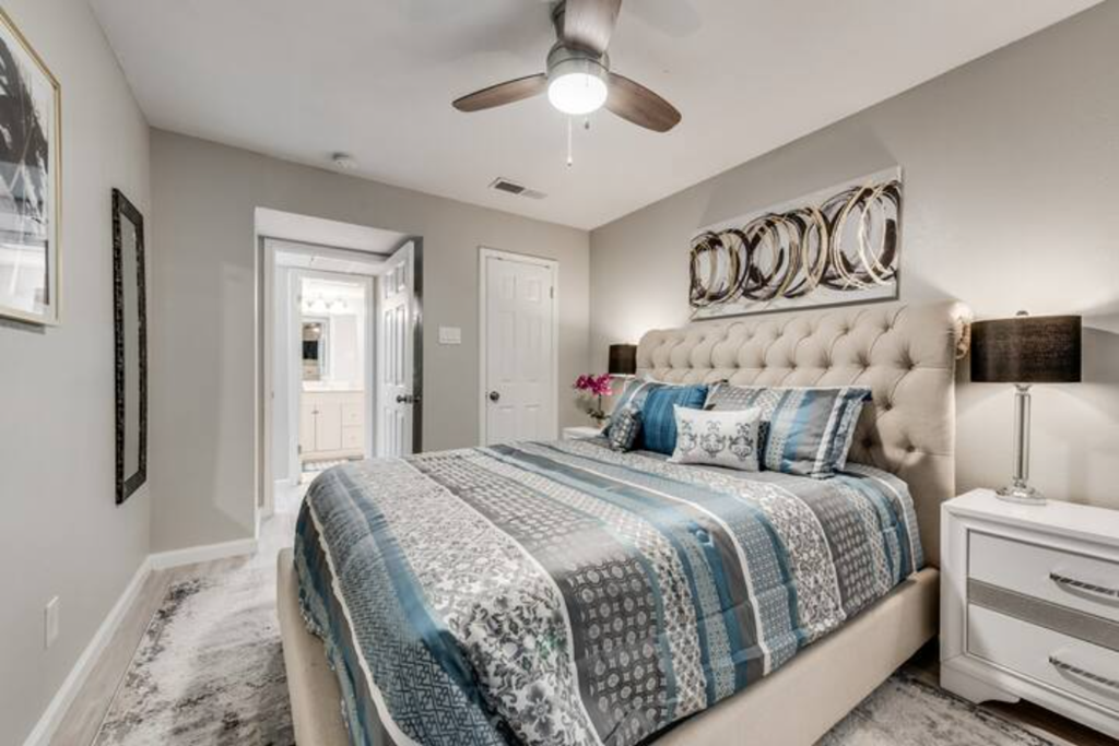 a bedroom with a bed and a ceiling fan