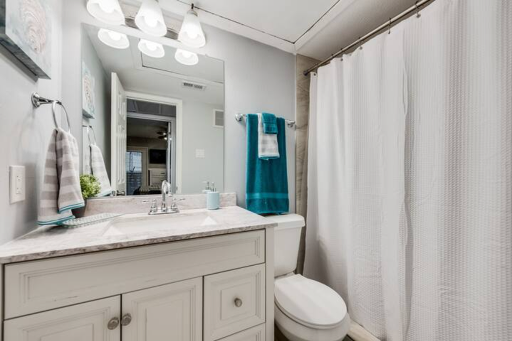 a white bathroom with a shower and a sink